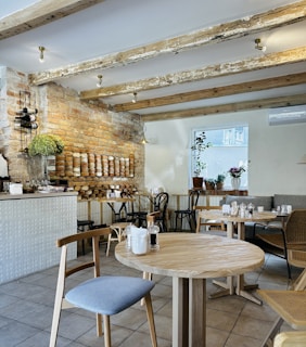 A rustic cafe interior featuring wooden beams and warm lighting, inviting guests to relax.