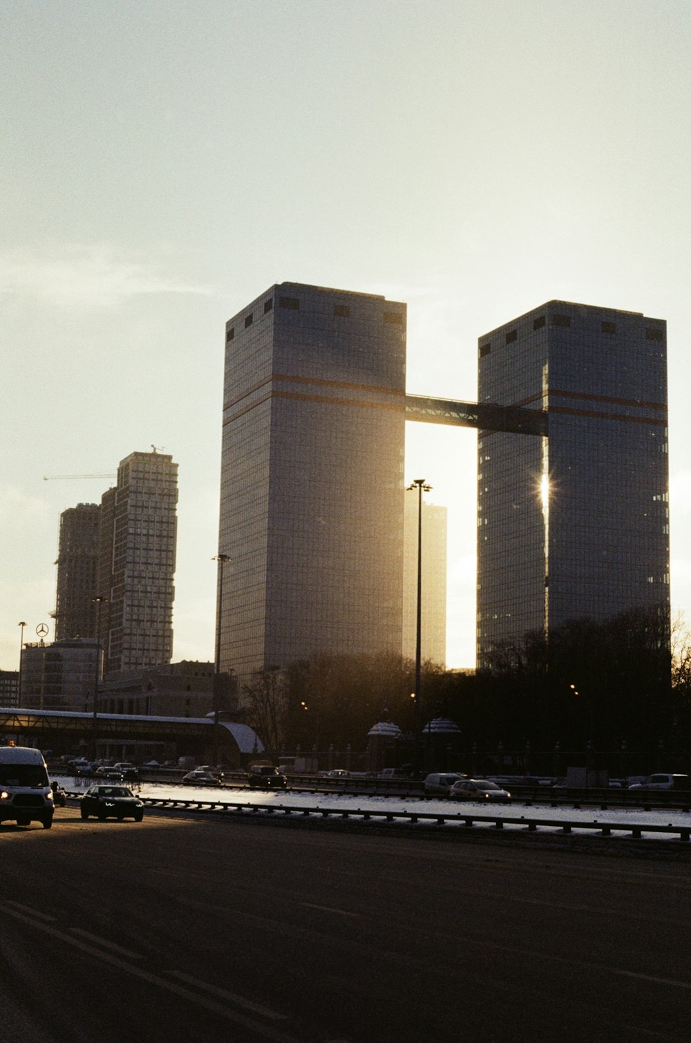 the sun is setting behind the tall buildings