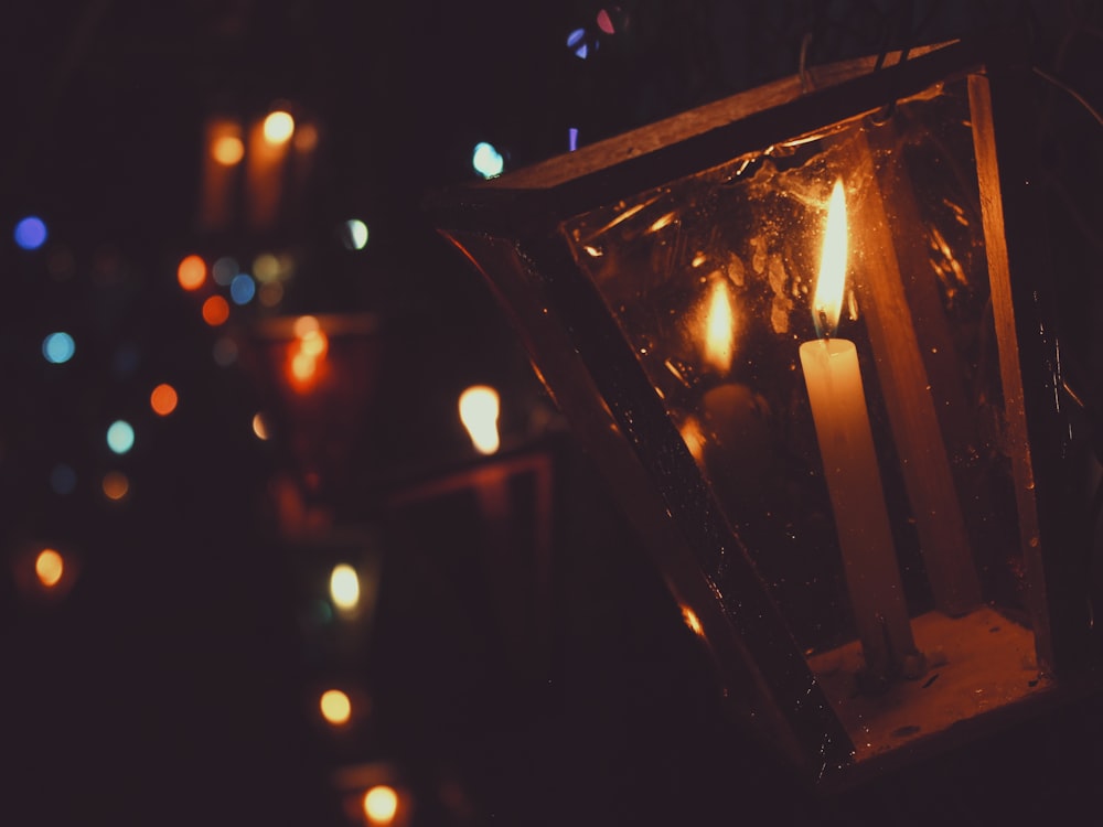 a lantern with lit candles in a dark room