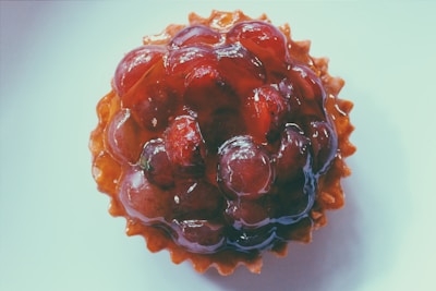 Close-up of a delicious freshly baked tart with a golden crust and vibrant fruit topping.