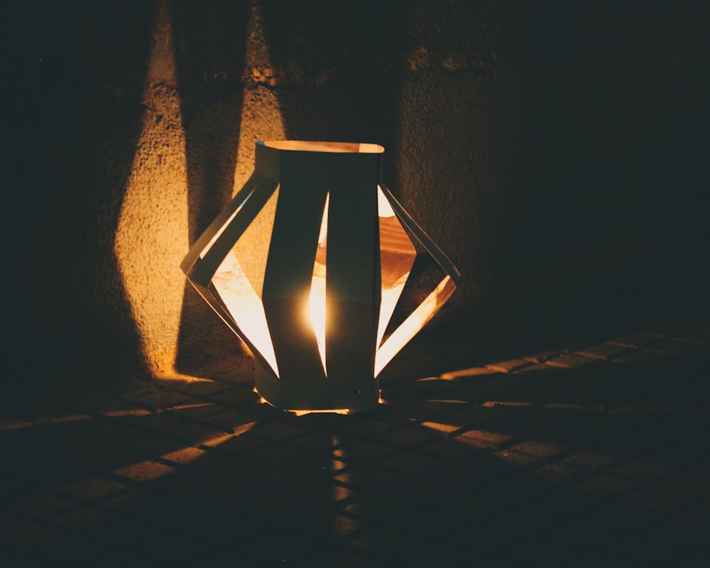 a lit lantern sitting on top of a table
