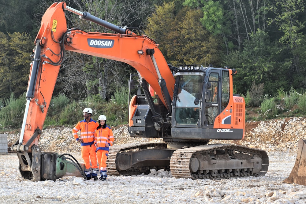 Un paio di uomini in piedi accanto a un veicolo da costruzione