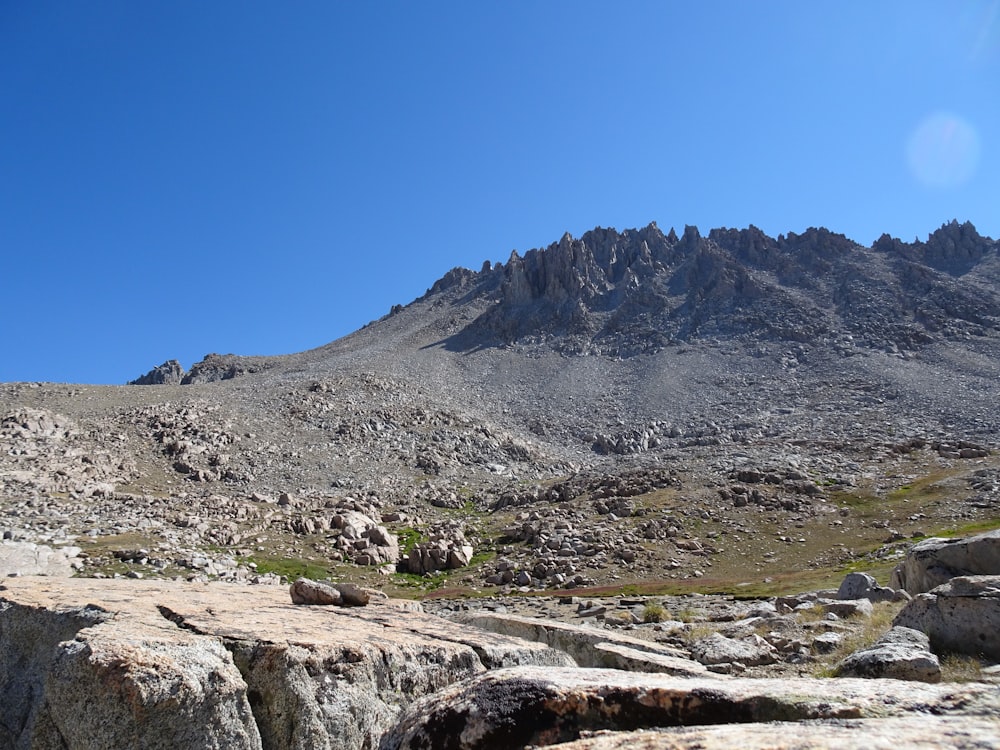 a rocky mountain range with a blue sky in the background