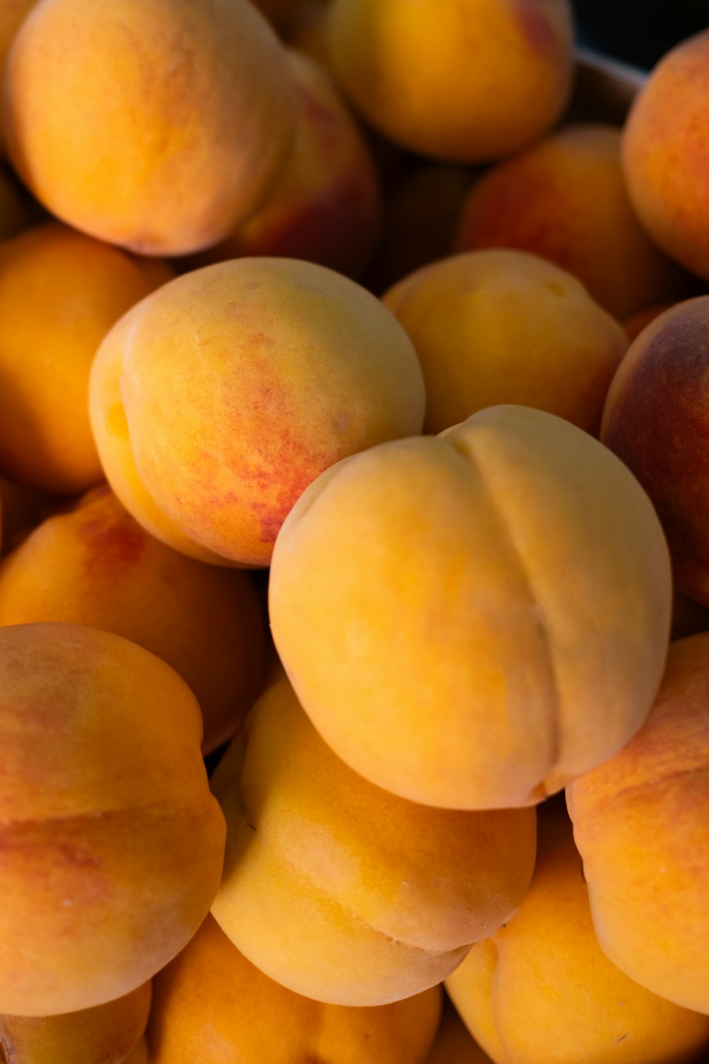 a pile of ripe peaches sitting on top of each other