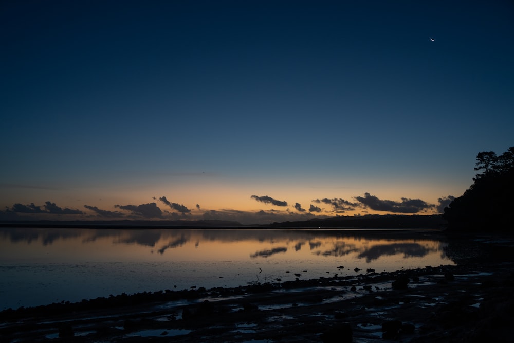 the sun is setting over a body of water