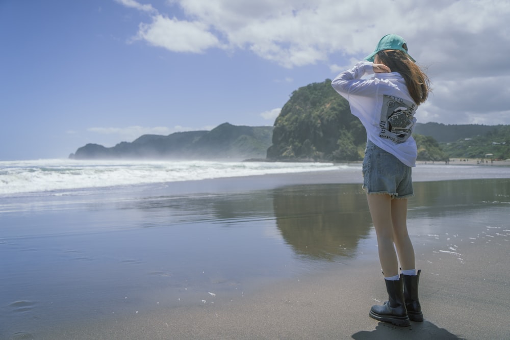 Una donna in piedi su una spiaggia vicino all'oceano