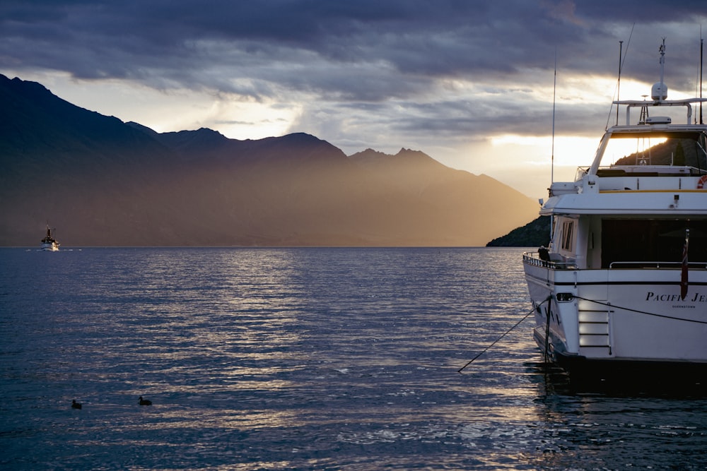 a white boat floating on top of a body of water