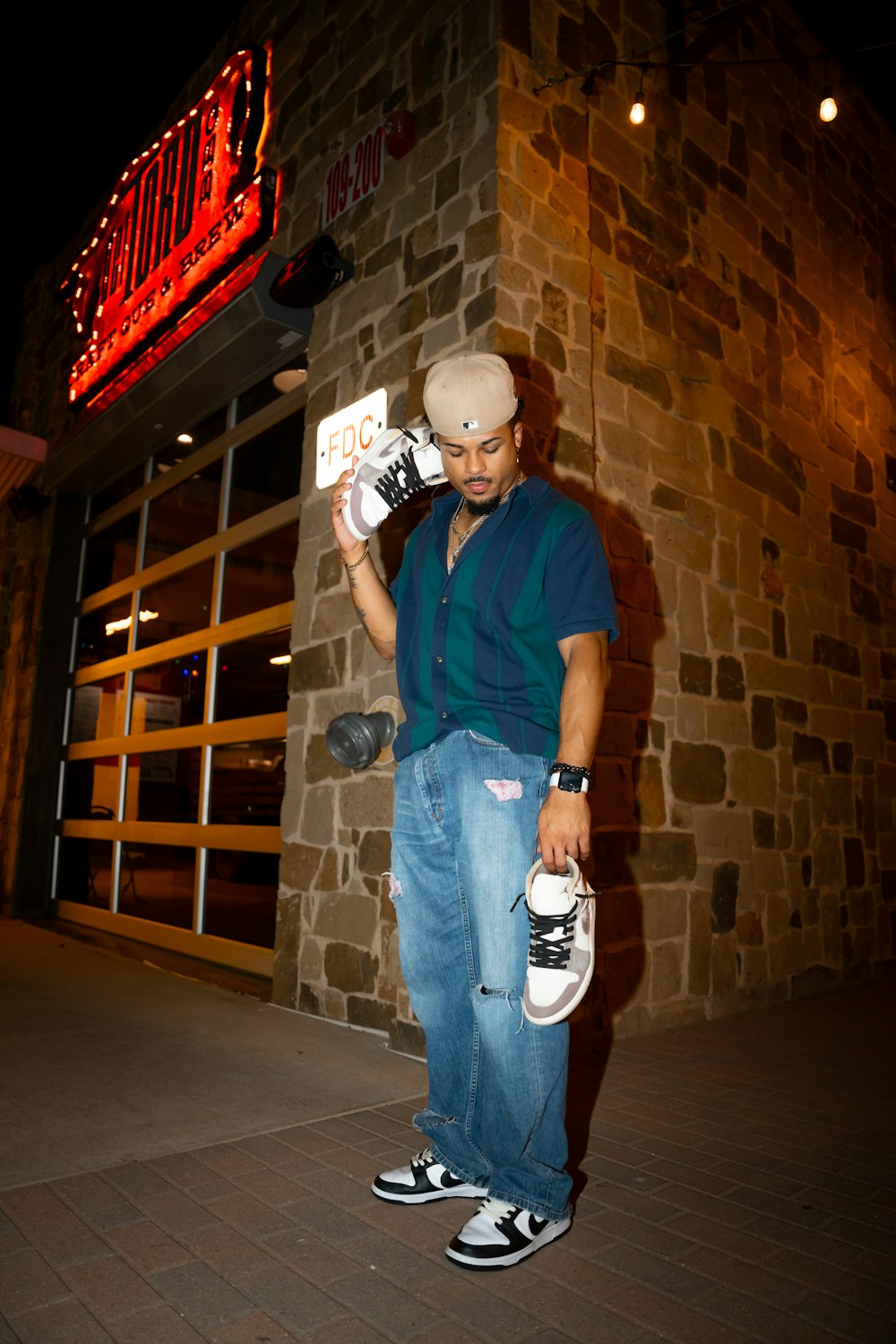 a man holding a skateboard in front of a building