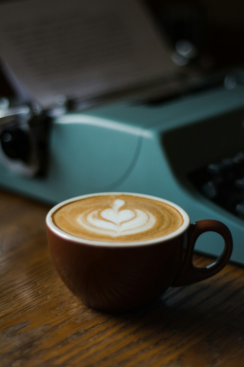 a cup of coffee sitting on top of a wooden table