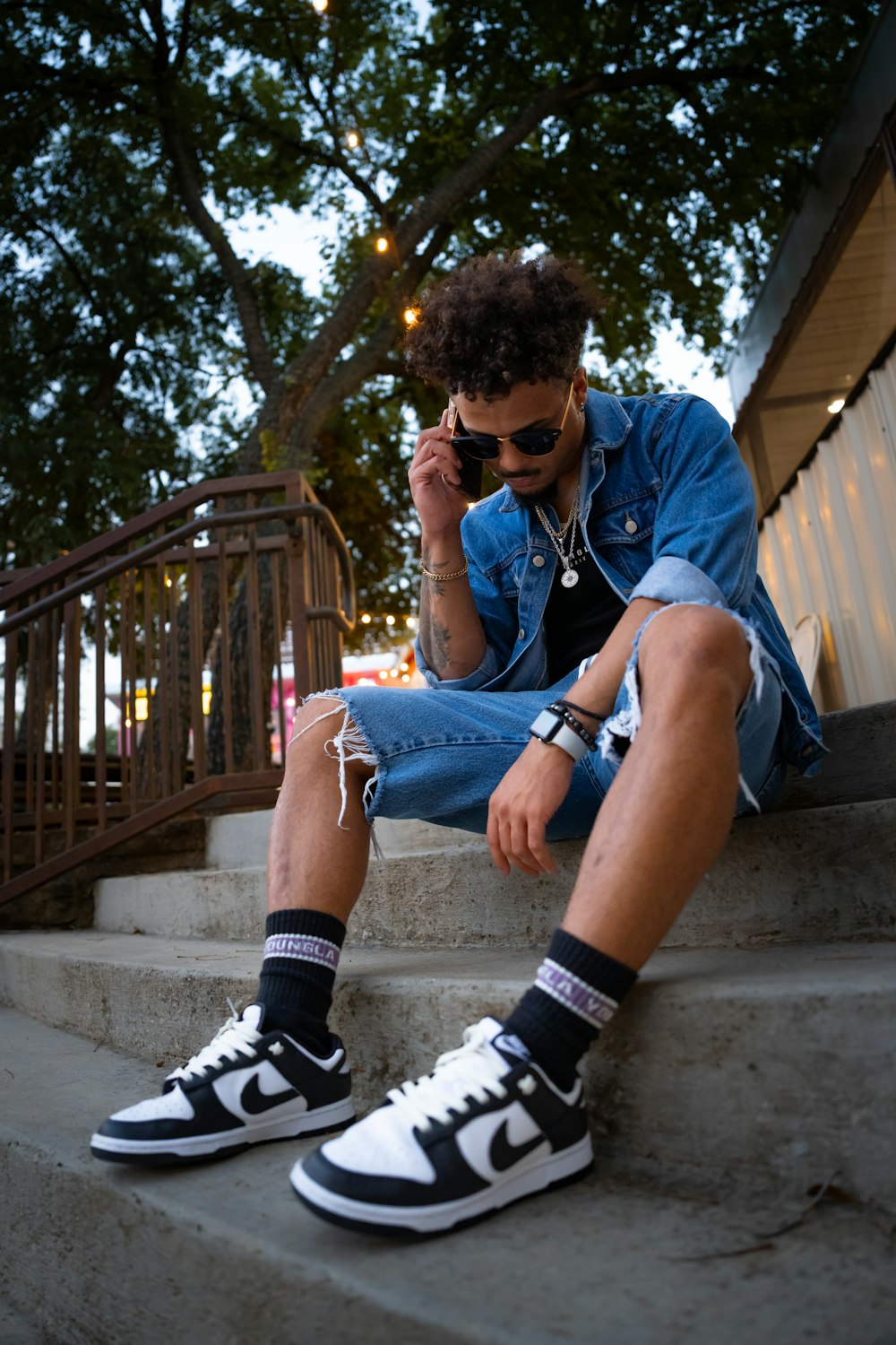 a man sitting on steps talking on a cell phone