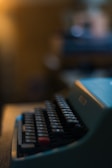 Close-up of a vintage typewriter keyboard with warm, dim lighting casting long shadows.