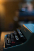 Close-up of hands typing on a vintage typewriter with soft sunlight.
