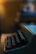 Close-up of a vintage typewriter with dramatic shadows on a dark background.