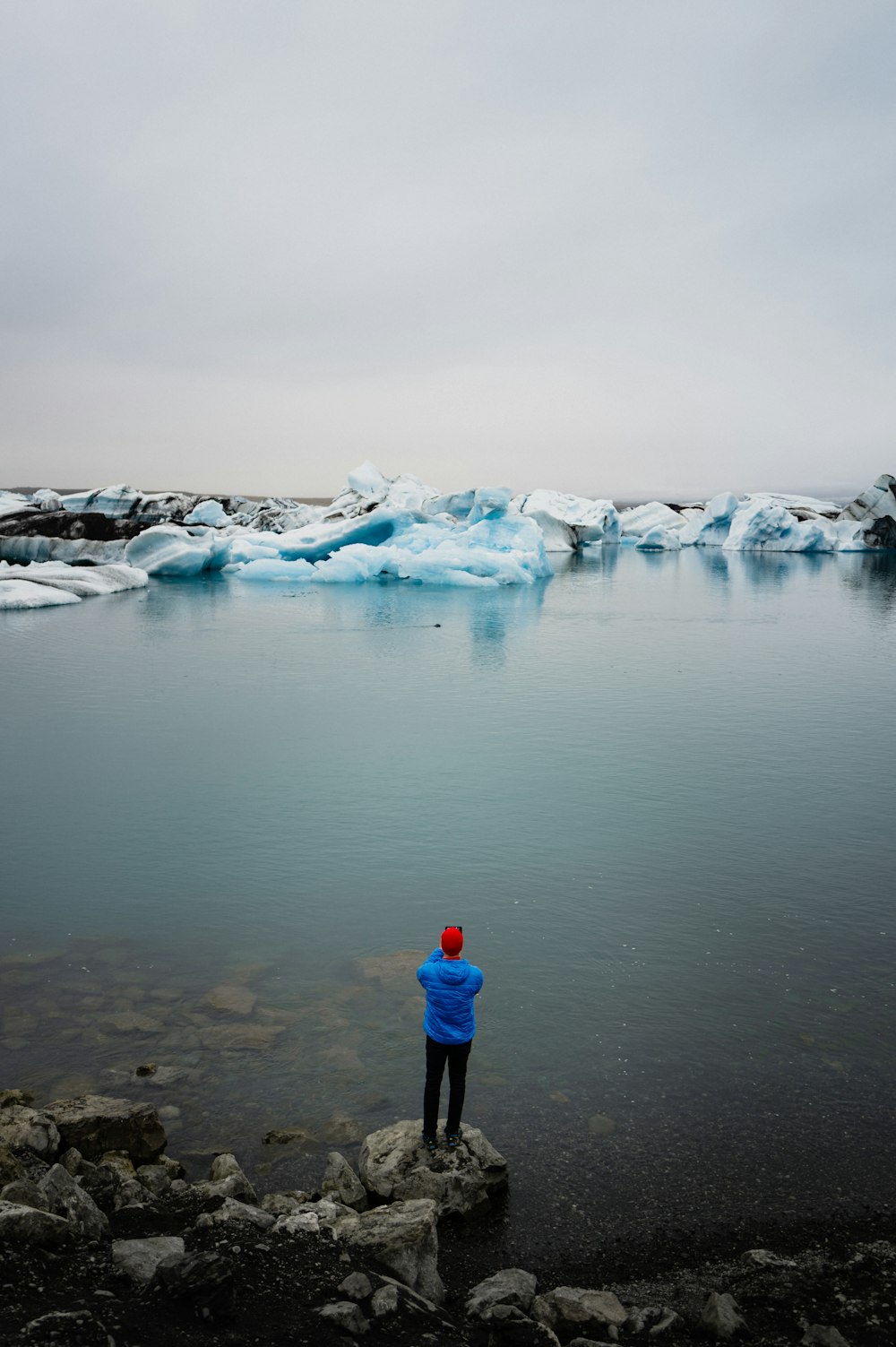 a person standing on a rock near a body of water