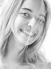 Black and white portrait of a person smiling candidly, shot on 35mm film.