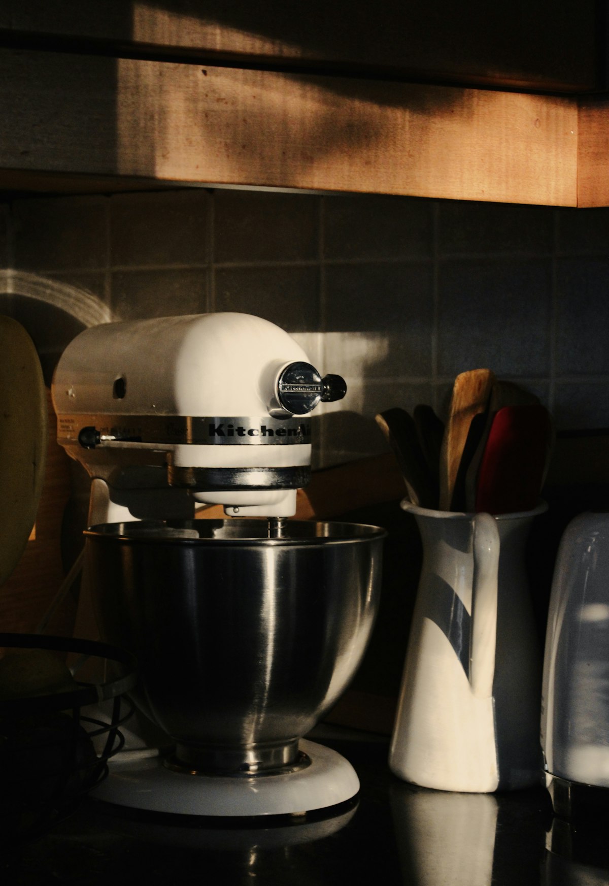 Batidora de pie blanca con bol de acero inoxidable sobre la mesada de una cocina