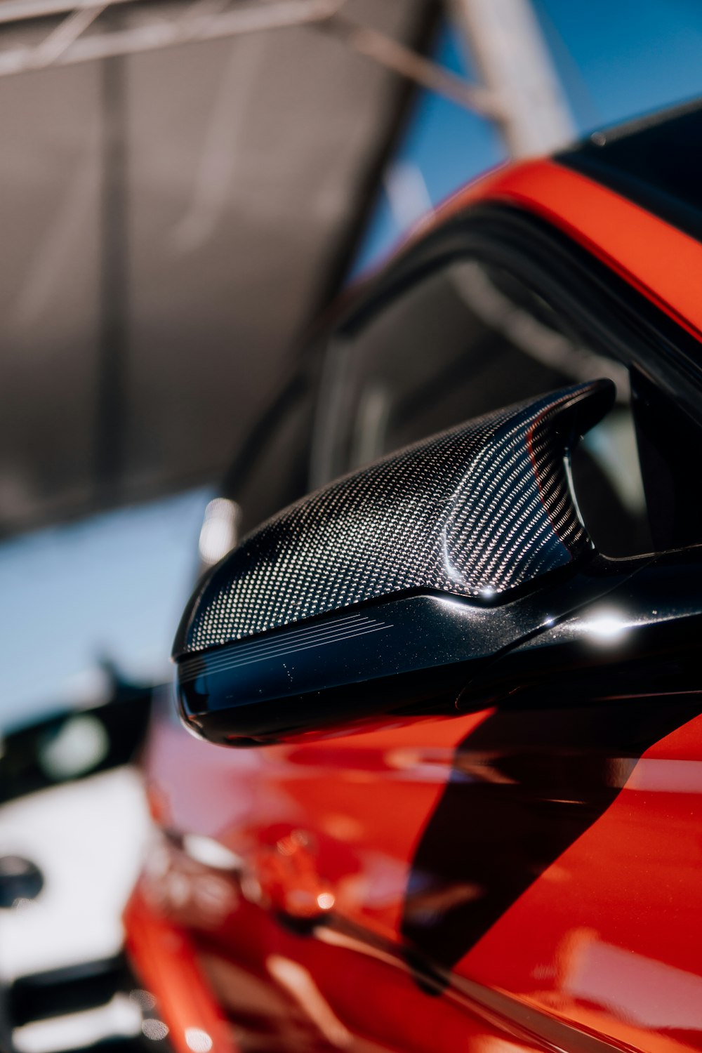 a close up of the side mirror of a red car