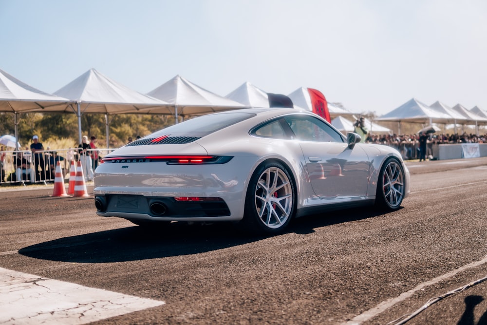 a white sports car driving down a race track