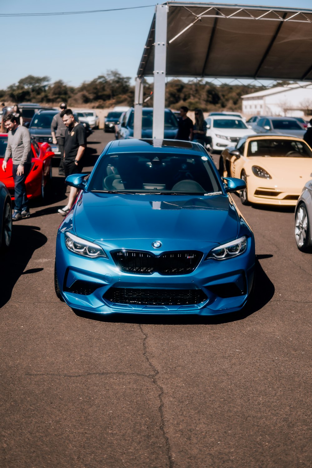 a blue car parked in a parking lot next to other cars