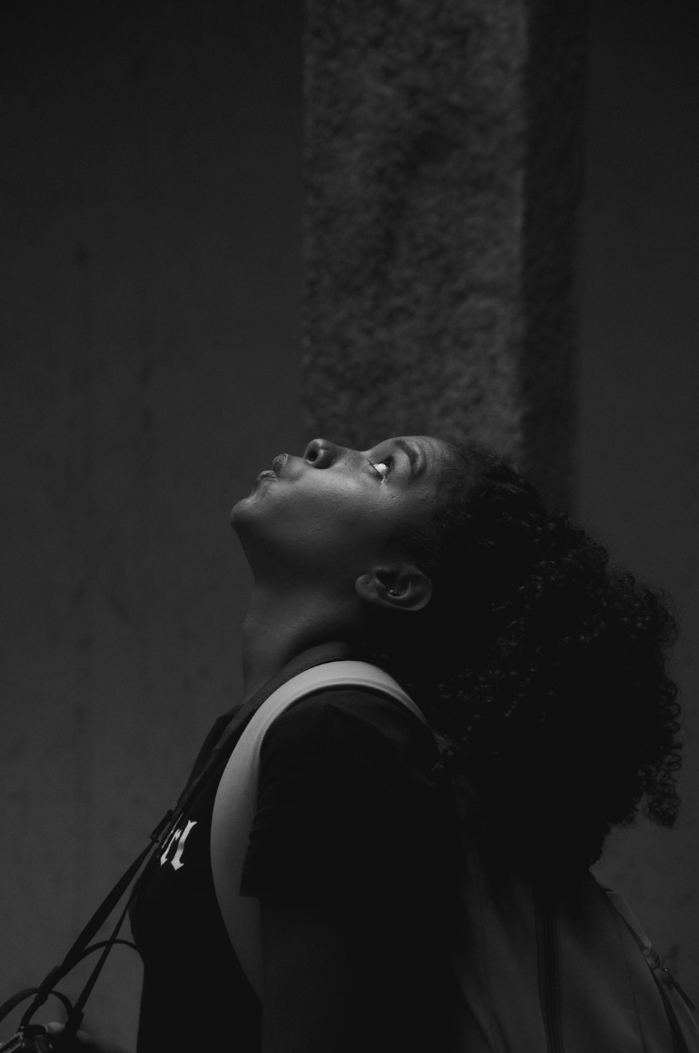 a black and white photo of a woman looking up