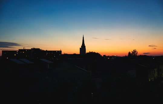 A vibrant Philadelphia cityscape at sunset with church steeples silhouetted against the colorful sky.