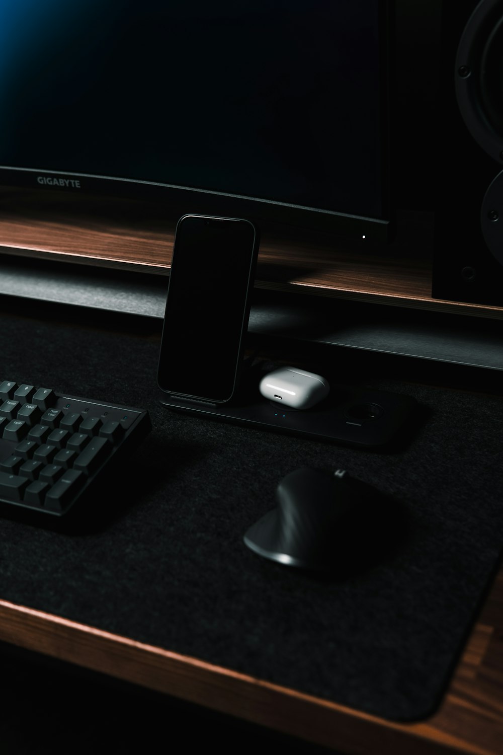 a computer keyboard, mouse, and cell phone on a desk