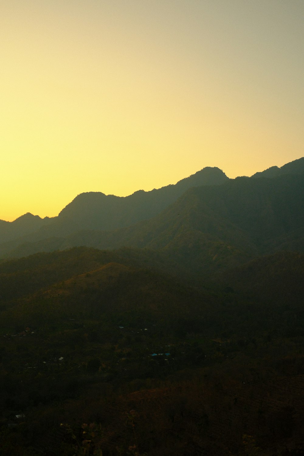 the sun is setting over a mountain range