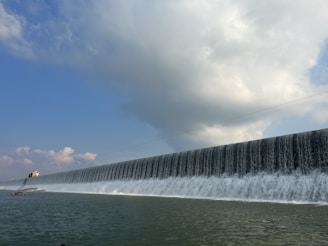 A panoramic view of a large hydroelectric dam with water cascading down.