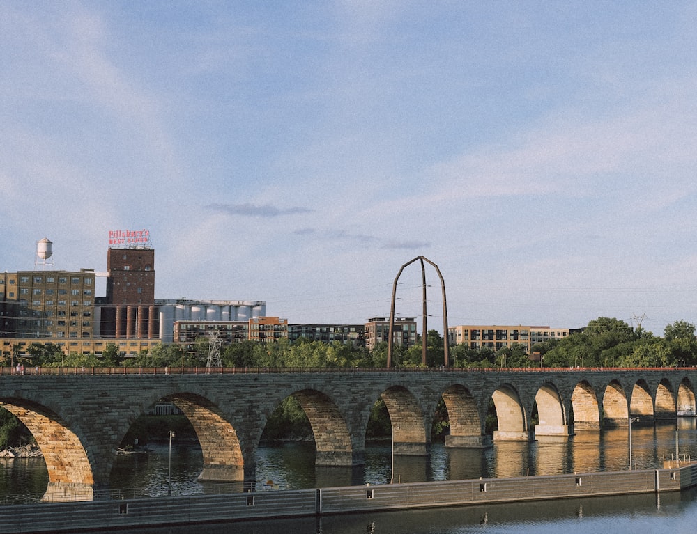 a bridge over a body of water with buildings in the background