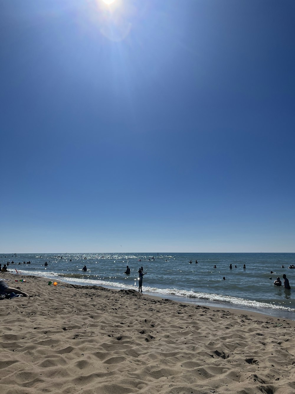 um grupo de pessoas em pé em cima de uma praia de areia