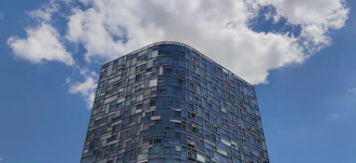 A completed commercial building with glass facade reflecting the sky
