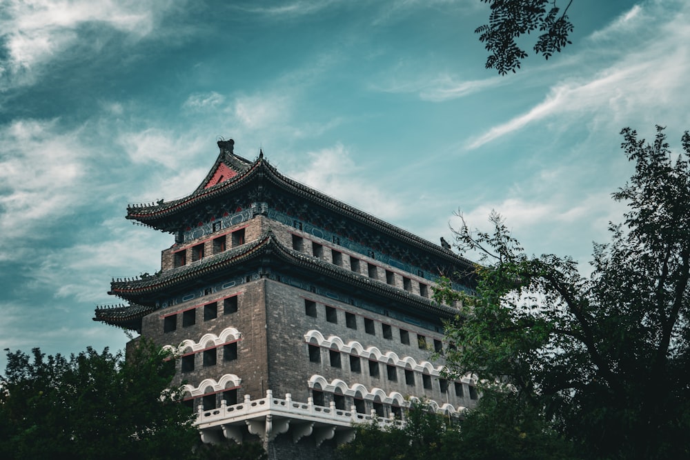 a tall building with a red roof surrounded by trees