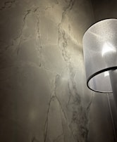 Elegant marble texture finish on a living room accent wall with soft lighting.