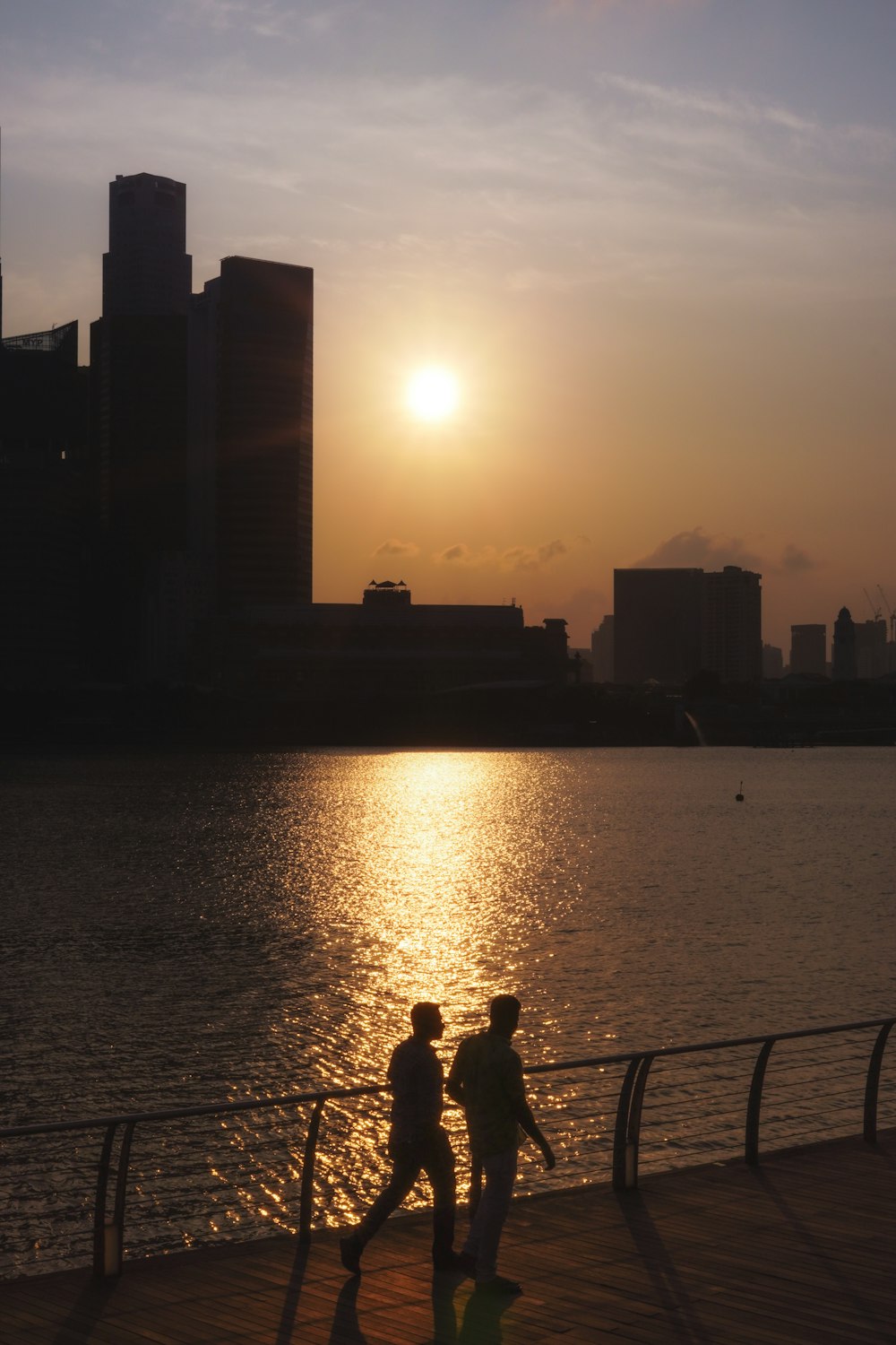 a couple of people that are walking by some water