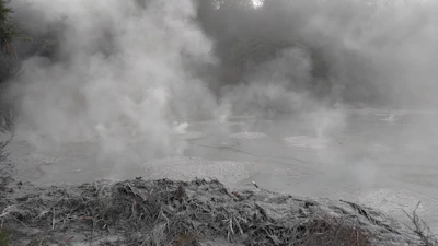 Steam rising gently from a traditional geothermal cooking pot nestled in volcanic stone.