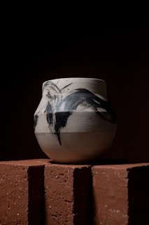 raku vase sitting on top of a brick wall