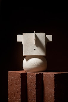 A minimalist sculpture casting dramatic shadows that evoke contemplation