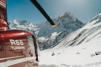 a helicopter flying over a snow covered mountain