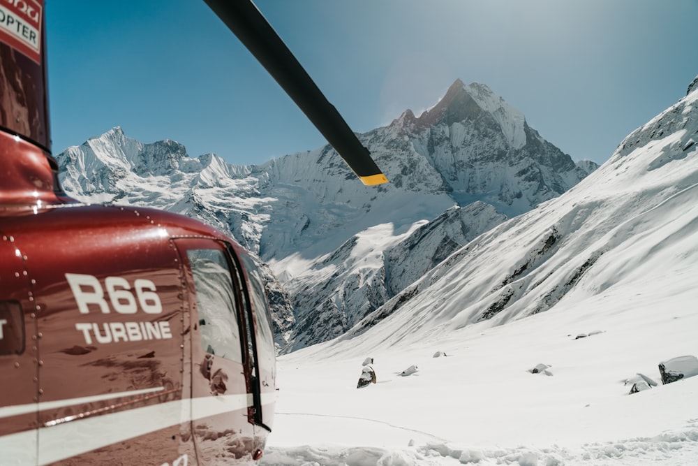 a helicopter flying over a snow covered mountain