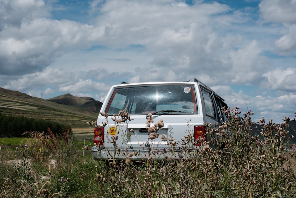 Ein weißer Lieferwagen, der auf einem Feld mit hohem Gras geparkt ist