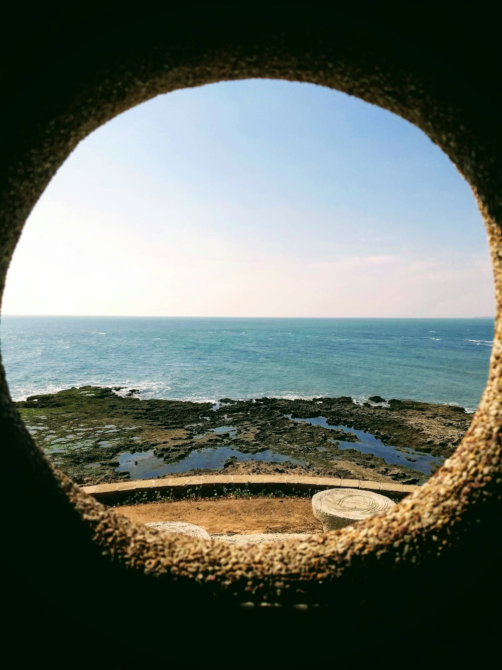 une vue sur l’océan à travers une fenêtre ronde