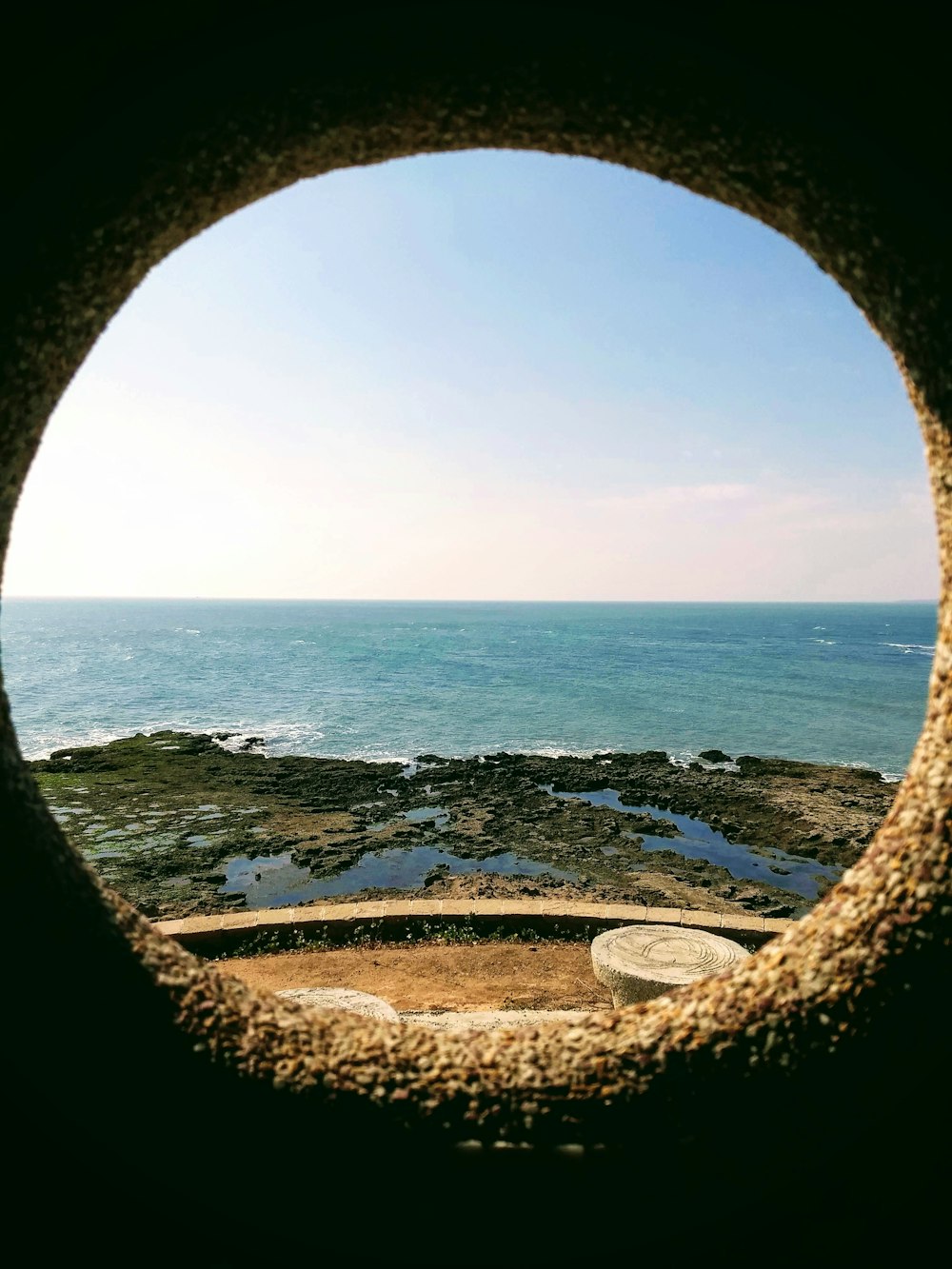 a view of the ocean through a round window