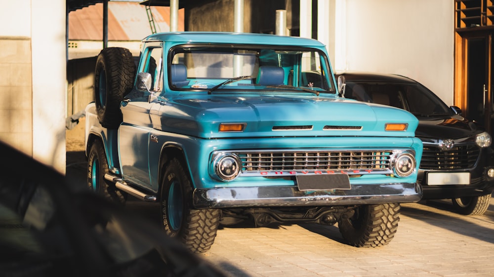 a blue truck parked next to a building