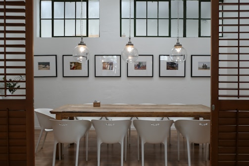Wide shot of a modern wooden dining table in a bright room.