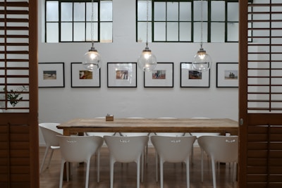 A spacious dining area with a large wooden table and ambient pendant lights.