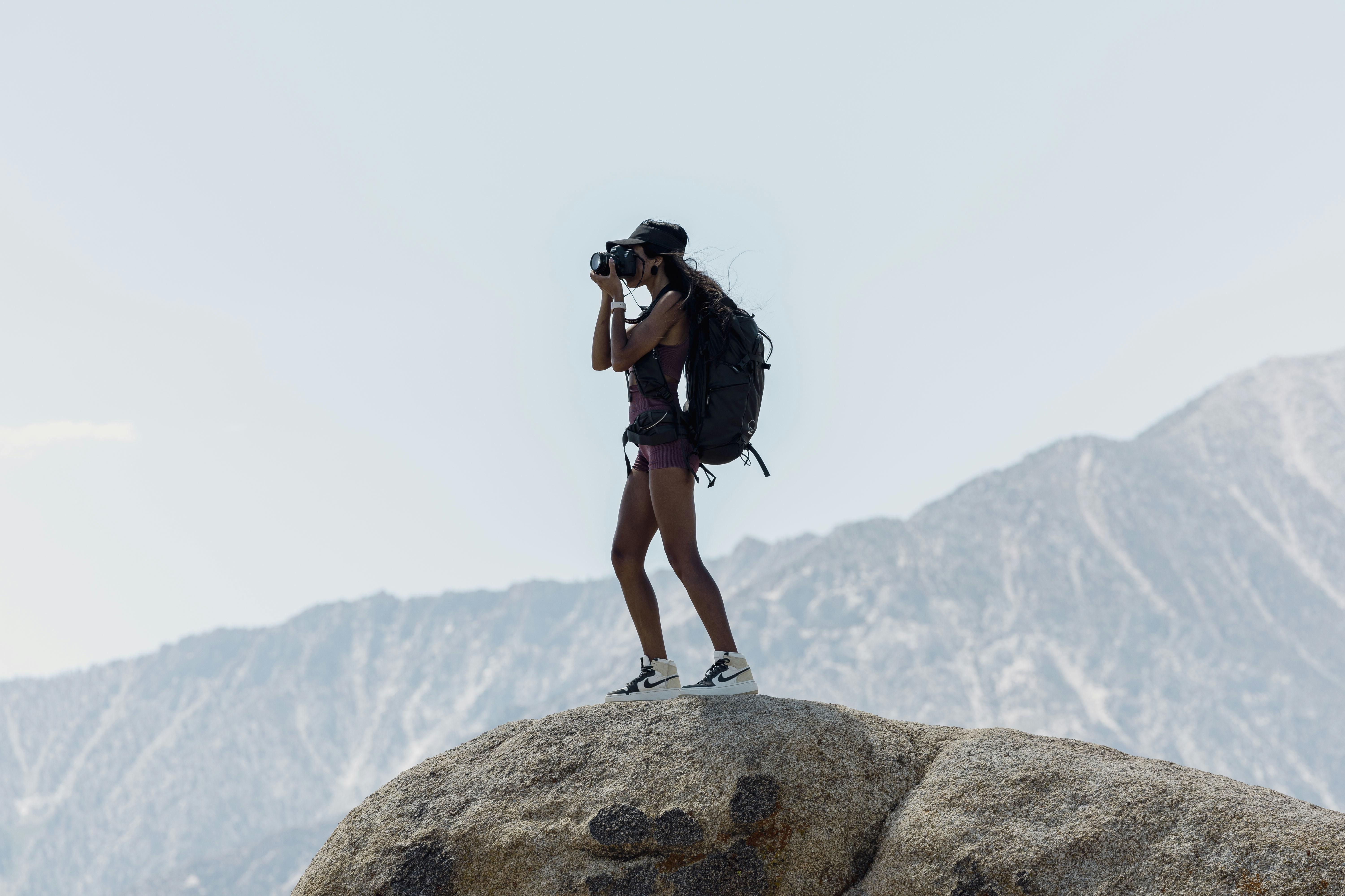 a woman standing on top of a large rock