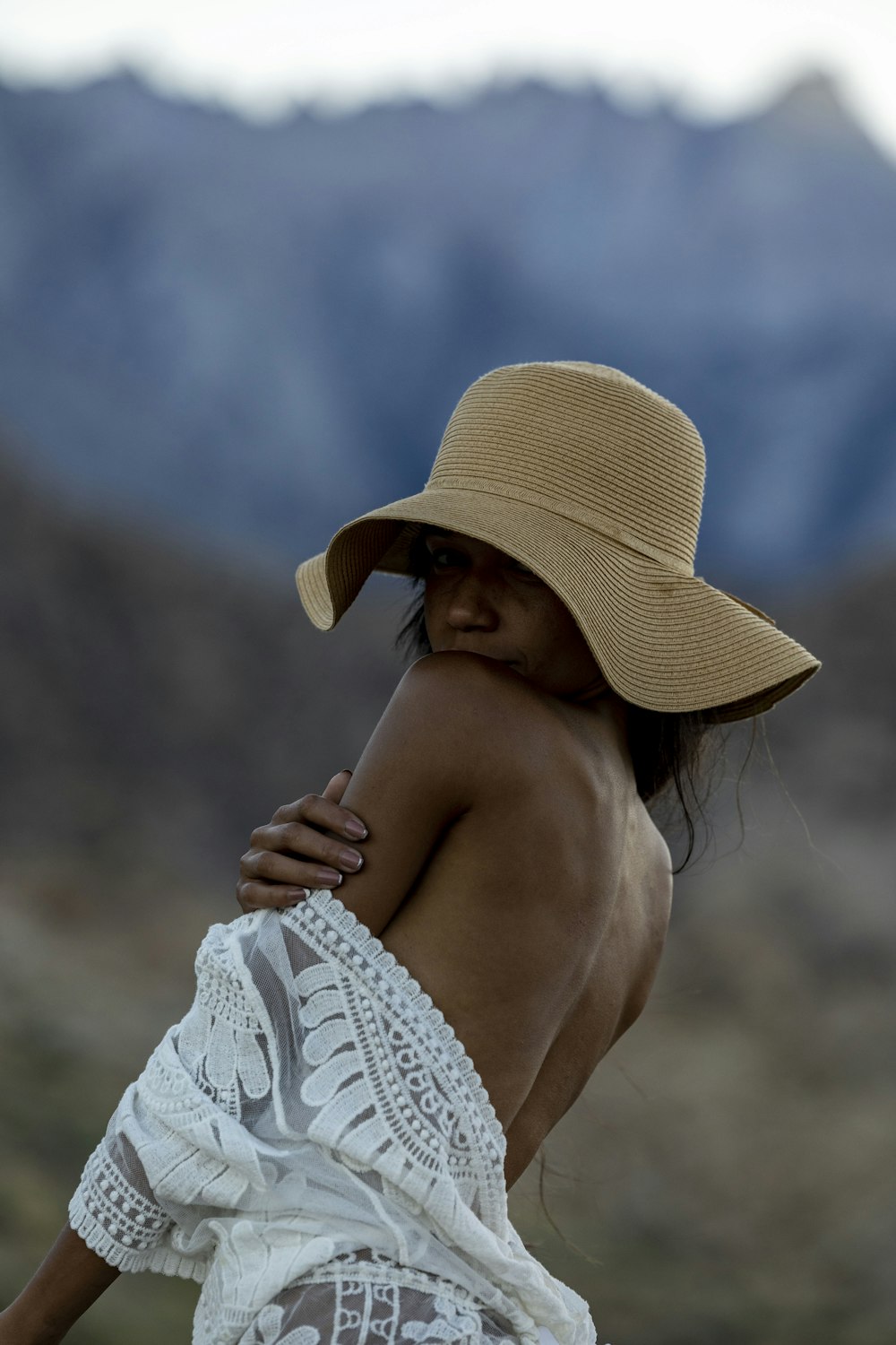 a woman wearing a hat and a white dress