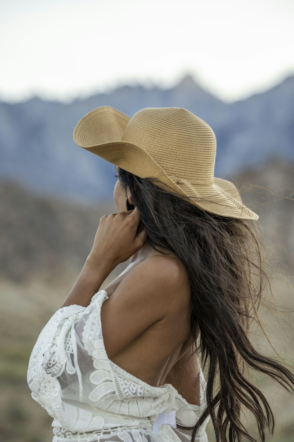 a woman wearing a hat talking on a cell phone