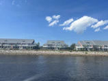 A row of sleek park homes nestled among greenery with the ocean visible in the distance