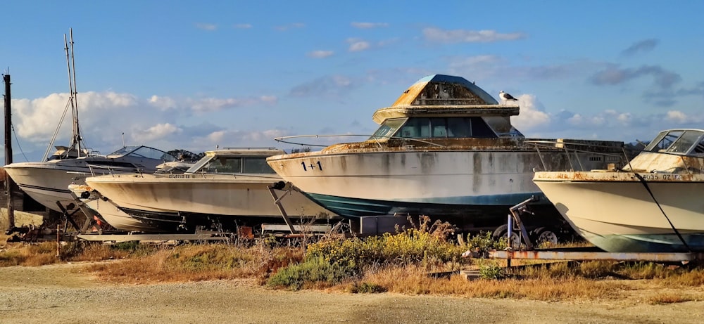 a group of boats sitting on top of a dry grass field